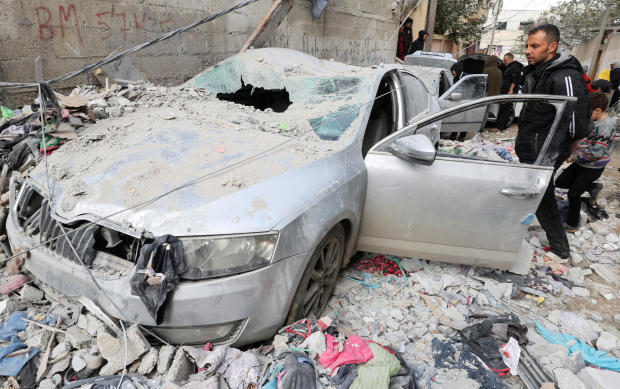 Palestinians inspect damaged vehicles at the site of an Israeli strike, amid the ongoing conflict between Israel and the Palestinian Islamist group Hamas, in Rafah in the southern Gaza Strip, Feb. 9, 2024. 