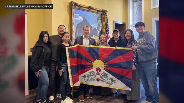 The mayor of Belleville holds the Tibetan flag along with Yangchen Nodong and her family. 
