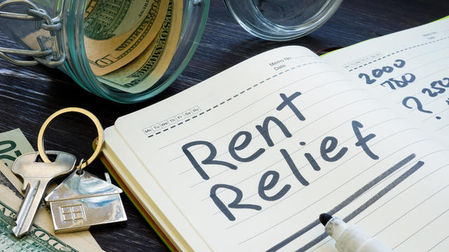 Rent relief sign and almost empty jar with money. 