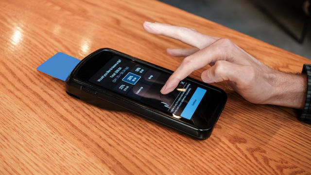 Man Pays Bill at Restaurant With Credit Card on Wireless Device 