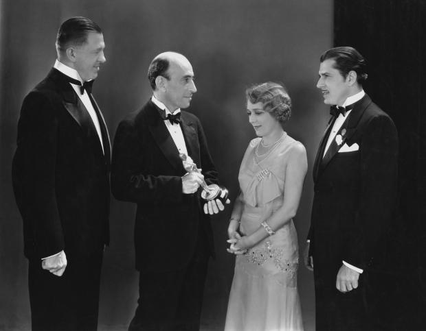 From left, Hans Kraly, winner of the Academy Award for writing; academy President William C. DeMille; best actress winner Mary Pickford; and best actor winner Warner Baxter are seen at the Oscars in Hollywood, California, April 3, 1930. 