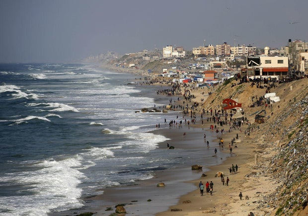 Palestinians wait for an airdrop of humanitarian aid by the Egyptian Air Force at the beach in Deir al Balah, Gaza, on Feb. 27, 2024.