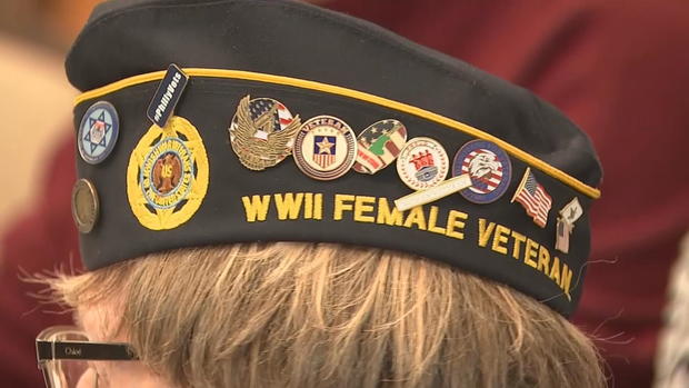 A photo of Brill's hat, which says WWII Female Veteran on the side, beneath numerous pins. 