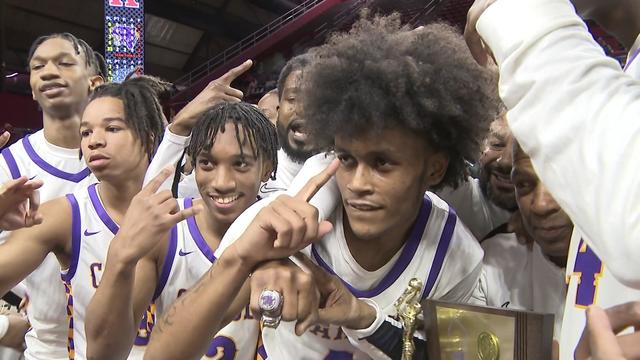 Camden High School basketball team members pose for a photo with their championship trophy. 