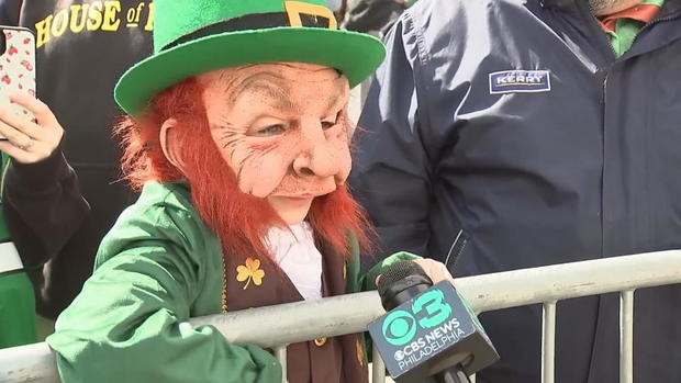 A boy dressed as a leprechaun speaks into a CBS News Philadelphia microphone at the St. Patrick's Day parade 