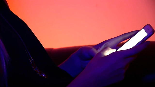 A person using a smartphone in a dark room 