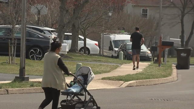 A person walks with a stroller and another runs nearby in the Montgomeryville neighborhood where a woman was attacked. 