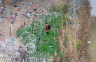In an aerial view, an immigrant faces coils of razor wire after crossing the Rio Grande from Mexico on March 17, 2024 in Eagle Pass, Texas. 