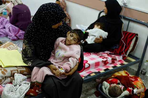 Palestinian woman Umm Mesbah Heji holds her malnourished daughter Israa, in Rafah in the southern Gaza Strip