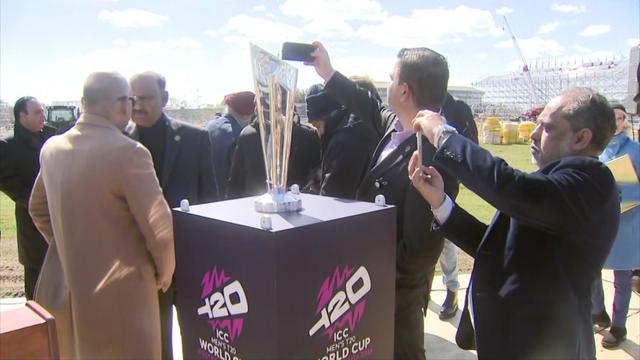 Individuals take photos of the Cricket World Cup trophy in Eisenhower Park. 