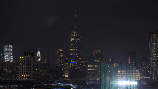 The New York Skyline is seen as the Empire State Building (C) lights were turned off during Earth Hour 2019. 