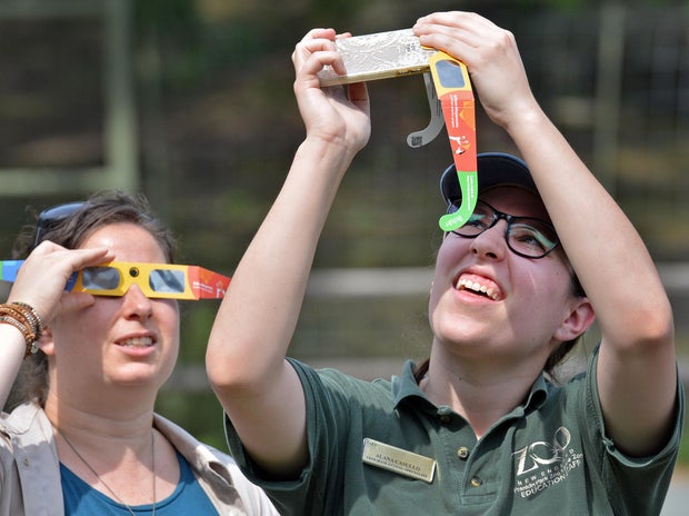 Spectators use viewing glasses to look at the eclipse on Aug. 21, 2017, in Boston, Massachusetts.