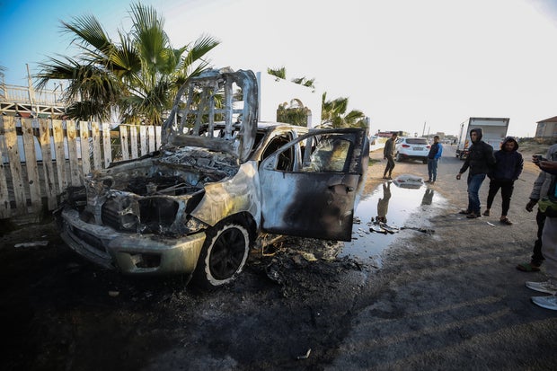 Palestinians stand next to a vehicle in Deir Al-Balah, in the central Gaza Strip, April 2, 2024, where employees from the World Central Kitchen were killed in an Israeli airstrike.World-Central-Kitchen-WCK-Aid-workers