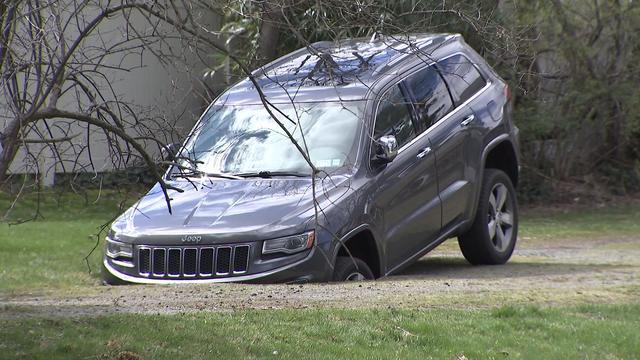 The front of a Jeep SUV sinks into the ground. 