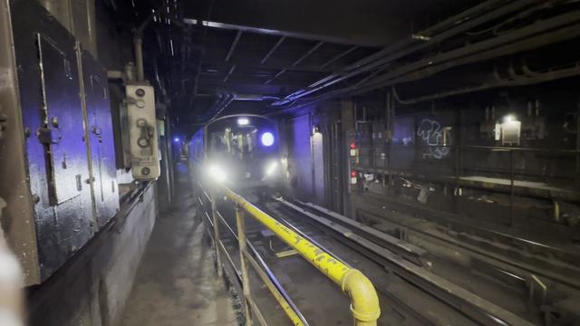 An A train coming through a tunnel. 