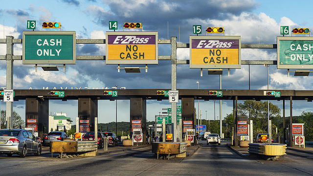 A highway toll plaza, with two E-Z Pass toll booths and two cash-only lanes 