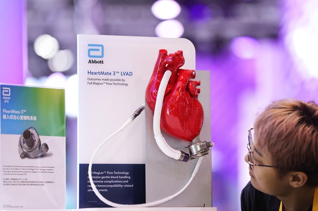 A visitor looks at a model of a HeartMate 3 device