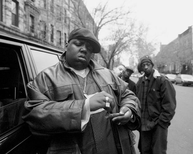 Rapper Notorious B.I.G., aka Biggie Smalls, rolls a cigar outside his mother's house in Brooklyn, New York, Jan. 18, 1995. 