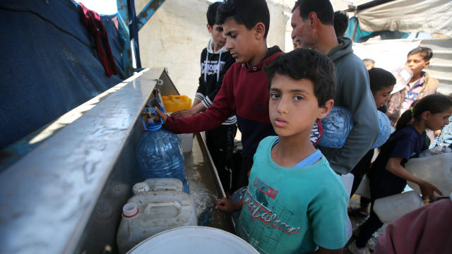 Palestinians wait in front of water dispensers in Rafah, Gaza, to meet their daily water needs April 17, 2024. 