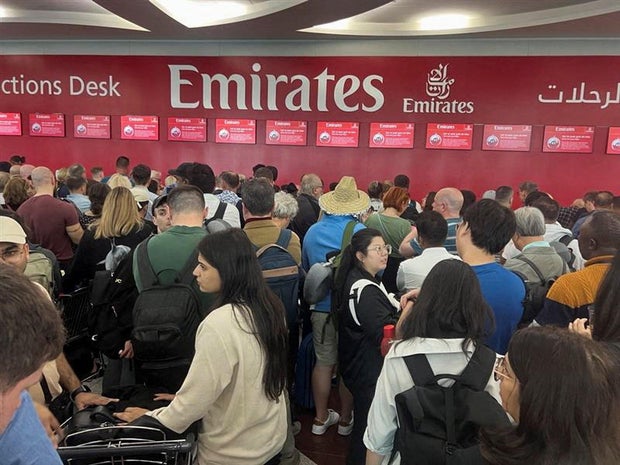 People queue at a flight connection counter after a storm hit Dubai, causing delays at Dubai International Airport