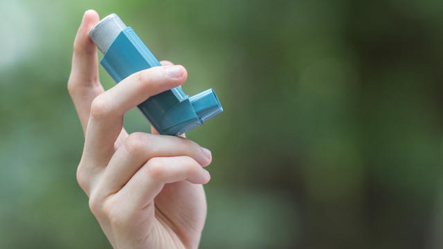 Asthma medecine inhaler holded by a man 