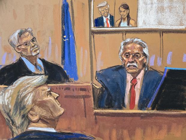 Former President Donald Trump looks on as David Pecker testifies in front of an image of Trump and Karen McDougal during Trump's criminal trial in New York on Thursday, April 25, 2024. 