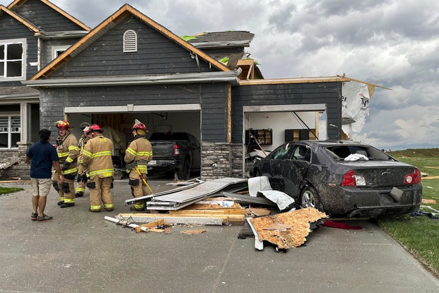 Firefighters work to clear a home damaged by a tornado near Omaha 