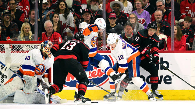 Mike Reilly #2 and Simon Holmstrom #10 of the New York Islanders play the puck and defend against Stefan Noesen #23 and Evgeny Kuznetsov #92 of the Carolina Hurricanes during the first period in Game Five of the First Round of the 2024 Stanley Cup Playoff 