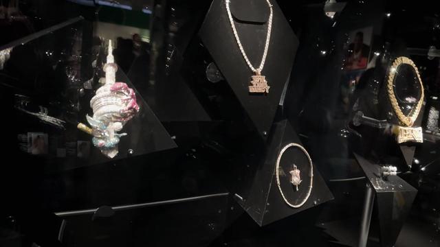 A collection of jewelry worn by hip-hop icons on display in a museum. 