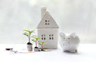 Model wood house and piggy saving with safety key for the investment of real estate.  Copy space for tax.  Real estate Concept 