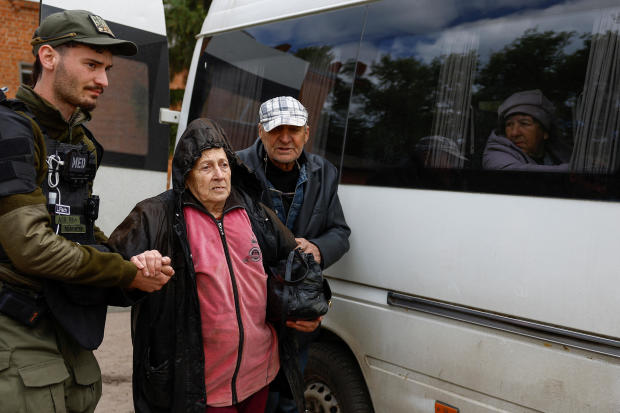 Volunteer assists an elderly couple from Vovchansk during their evacuation to Kharkiv due to Russian shelling near a border in Kharkiv region 