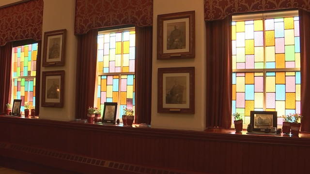 Light shines into Mother Bethel Church through three stained glass windows, which are made up of rectangular panels of different colors 