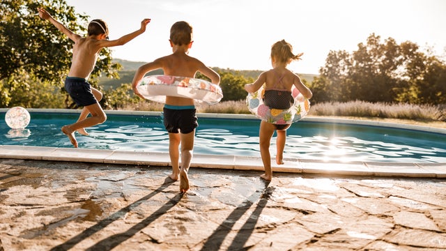 Playful siblings having fun during summer day at the pool. 