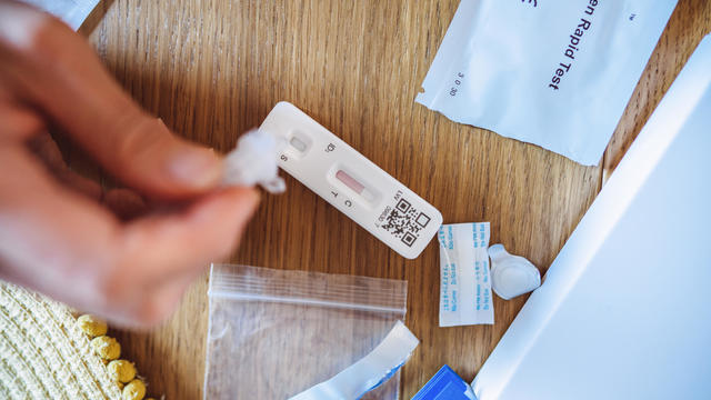 A woman using Covid-19 rapid self-test kit at home 