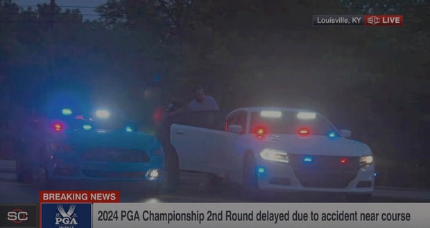 In this still image made from video provided by ESPN, Masters champion Scottie Scheffler is escorted to a police car after being handcuffed near Valhalla Golf Club, the site of the PGA Championship golf tournament, early May 17, 2024.