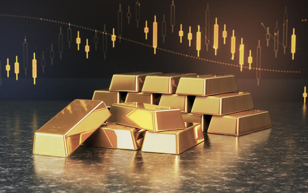 Gold Bars & Sitting on Financial Chart Background 