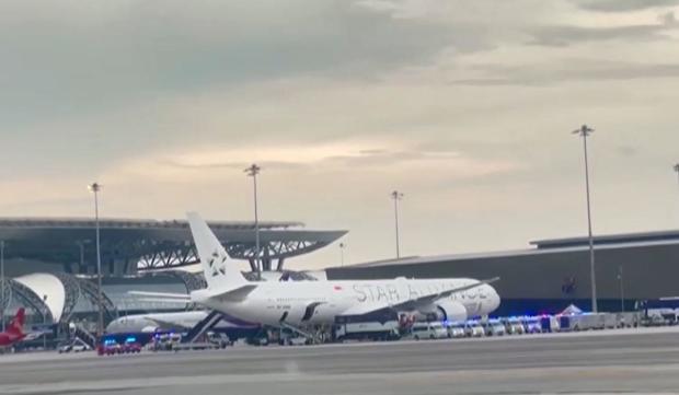 An image taken from video shows a Singapore Airlines Boeing 777-300ER sitting on the tarmac at Bangkok's Suvarnabhumi Airport surrounded by emergency vehicles on May 21, 2024, after flight SQ321 from London to Singapore was diverted after encountering severe turbulence. 