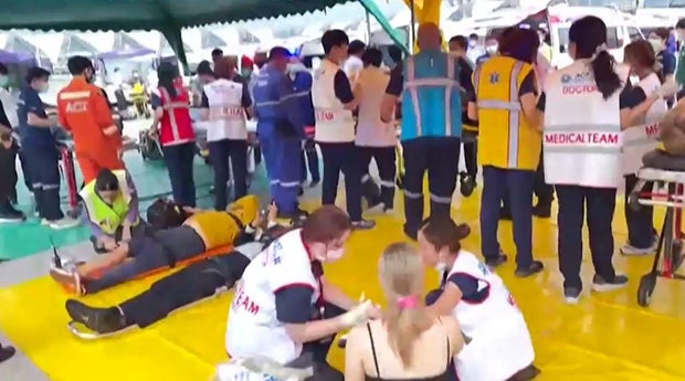 Emergency doctors assess and treat people affected by severe turbulence on board Singapore Airlines flight SQ321 in a screening area at Bangkok Suvarnabhumi Airport on May 21, 2024, after the flight from London to Singapore was diverted to the Thai airport.