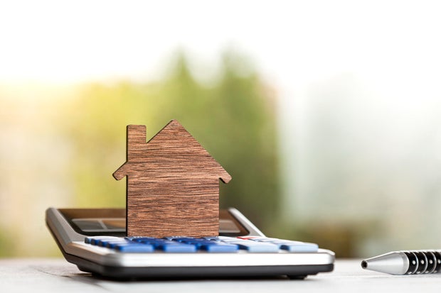 Wooden silhouette of a house on a calculator