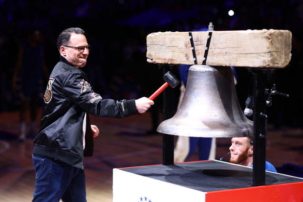 Gov. Josh Shapiro, wearing a retro 76ers jacket, rings the bell at the Wells Fargo Center before a Philadelphia 76ers game 