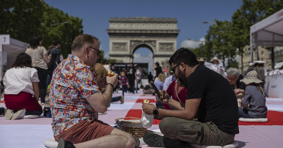 Paris’ famous Champs-Elysees turned into a mass picnic blanket for an unusual meal