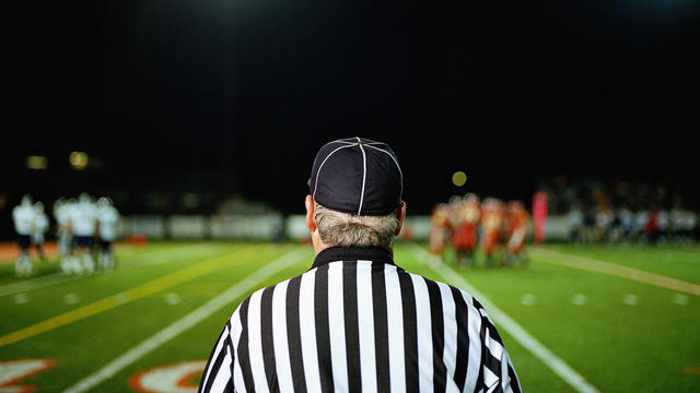 American football referee on field, rear view 