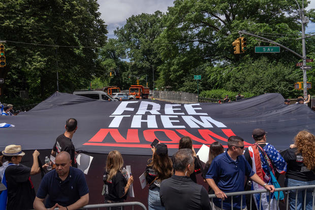 A large 'Free them now' flag is held at the Israel Day on Fifth parade on June 2, 2024 in New York City. 
