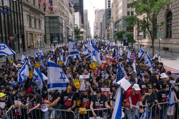 People hold Israeli flags as they take part in the Israel Day on Fifth parade on June 2, 2024 in New York City.