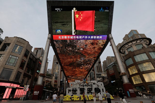 Screen shows news footage of a Chinese national flag carried by Chang'e-6 probe's lander on the moon, in Beijing 