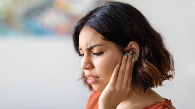 Young Woman Suffering From Earache At Home 