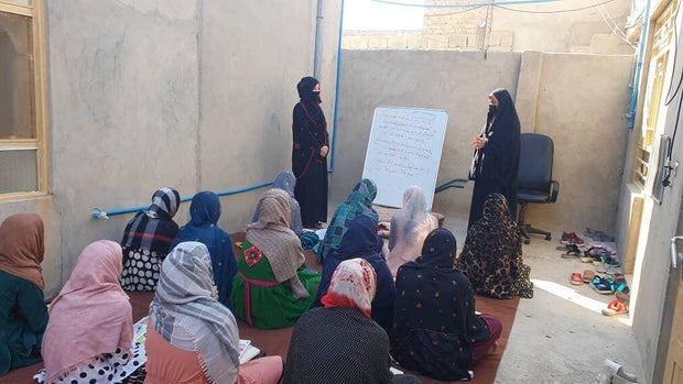 Teenagers and their teacher Sherin are seen at an underground school supported by the Pohana Fund in Helmand province, southern Afghanistan, in early June 2024.