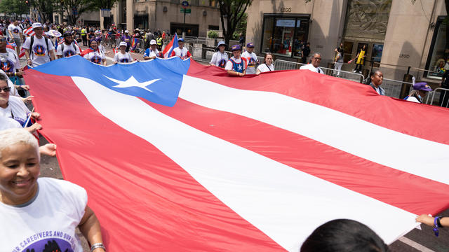Parade participants carry an enormous Puerto Rican flag down Fifth Avenue in Manhattan. 