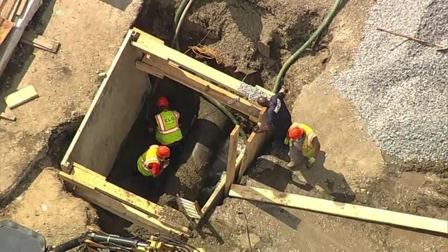 An overhead view of several workers working on a sewer force main pipe in Ossining. 