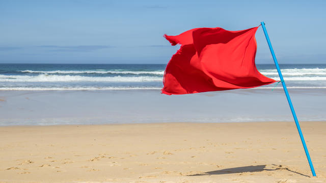 Red flag on an empty beach 